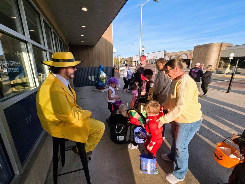 Safe Trick or Treat Night A One-Stop team member in a bright yellow costume handing out candy to young trick-or-treaters outside the One-Stop office in downtown Lewistown